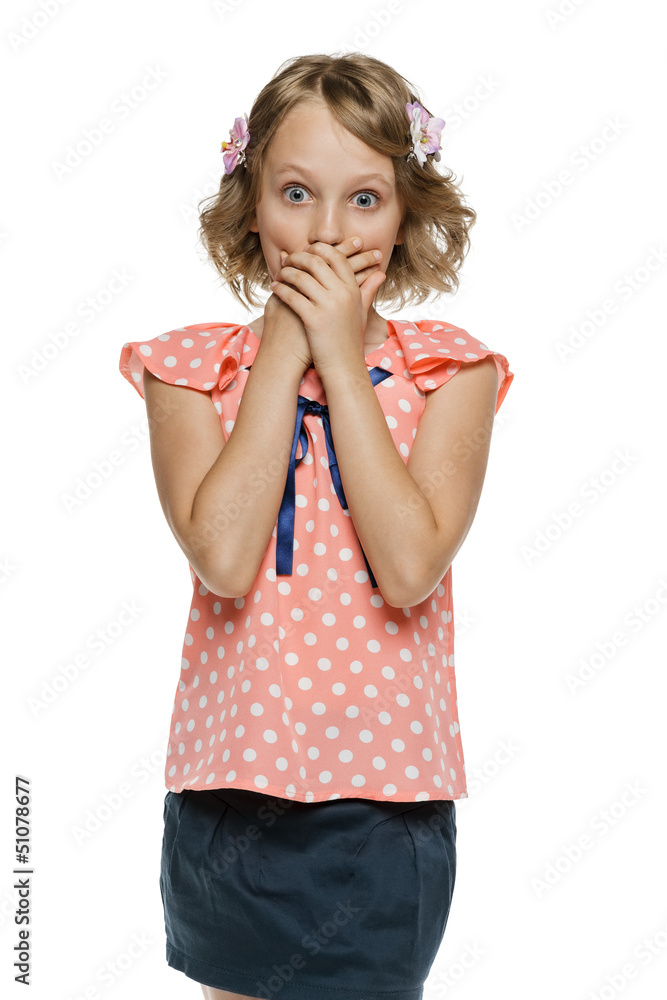 Frightened little girl standing with hands over mouth Frightened little girl standing with hands over mouth