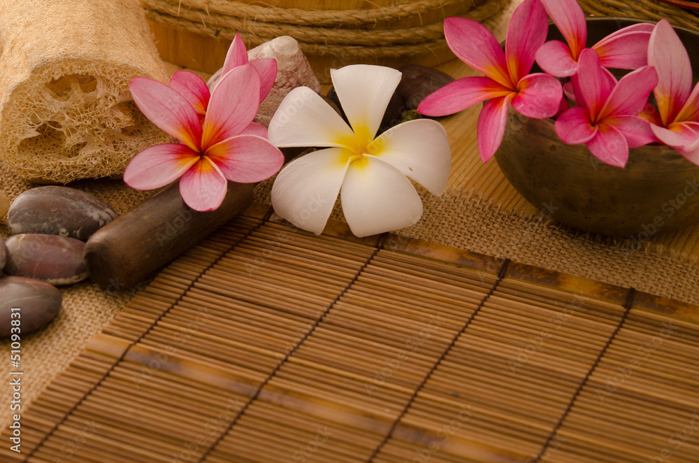 tropical spa setup with frangipani flower hot rocks and massage