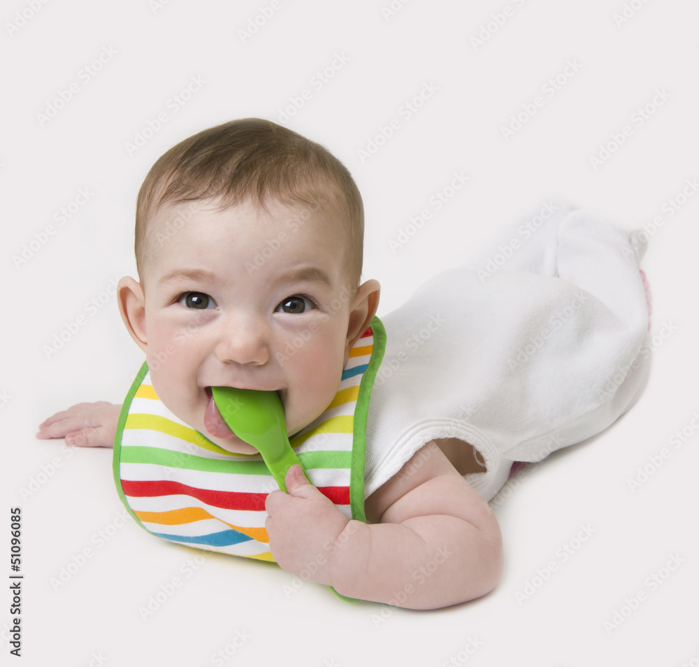 Baby with spoon in mouth looking at camera Baby with spoon in mouth looking at camera
