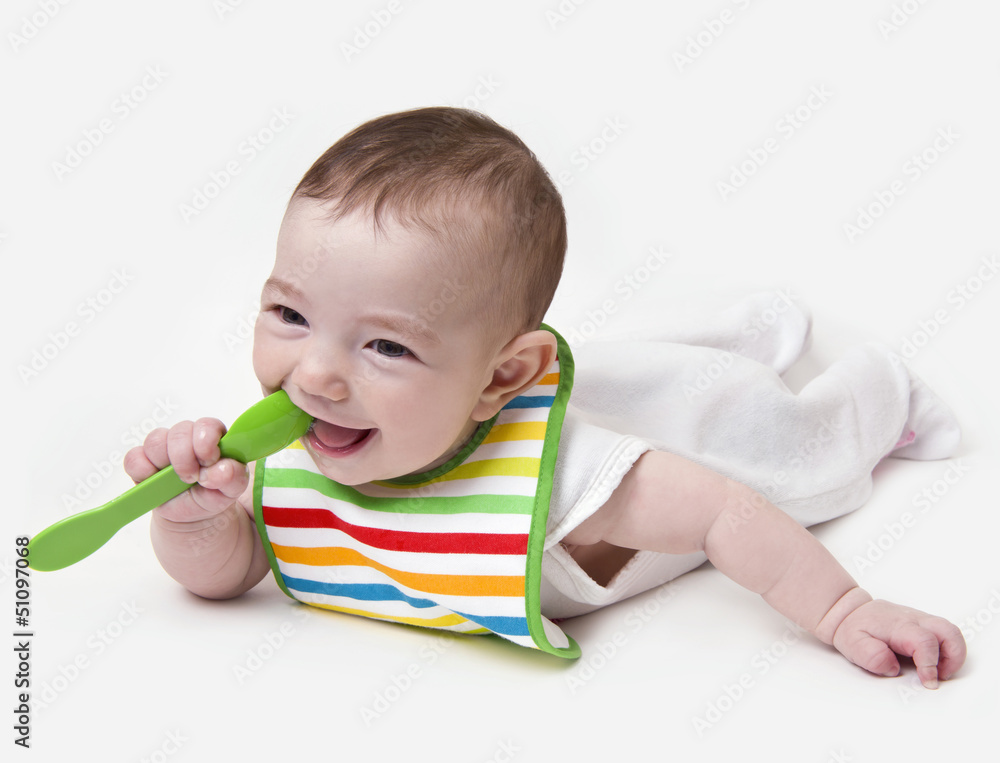 Smiling infant baby with spoon in mouth Smiling infant baby with spoon in mouth