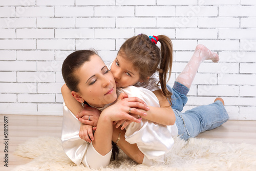 daughter riding on mom hugs and kisses her