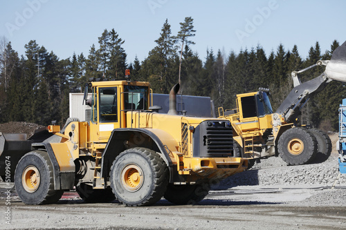 heavy duty trucks working inside gravel industry pit