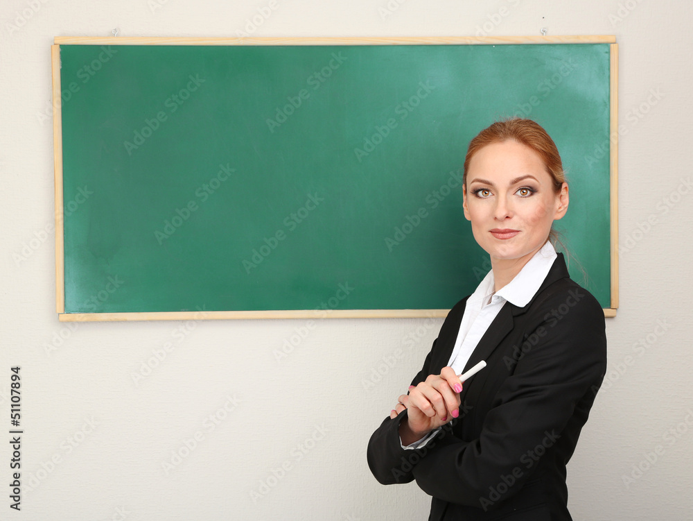 Portrait of teacher woman near chalkboard in classroom Portrait of teacher woman near chalkboard in classroom