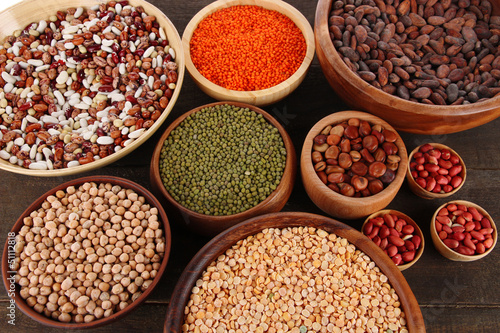 Different kinds of beans in bowls on table close-up