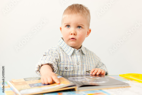 curious baby boy studying wiht the boock