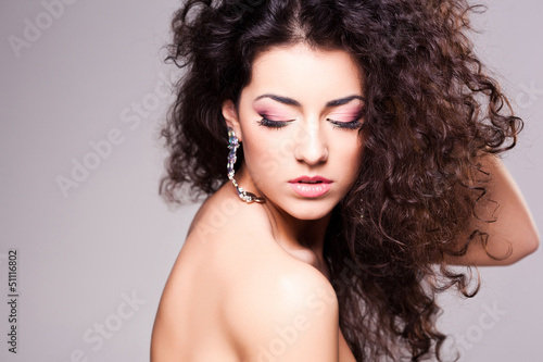 cute girl with curly hair wearing make-up - studio shot