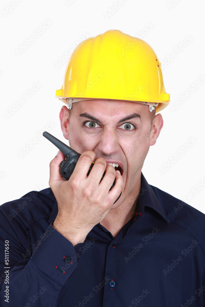 businessman wearing helmet and shouting on a walkie talkie businessman wearing helmet and shouting on a walkie talkie
