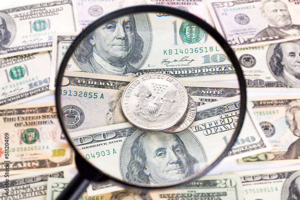 Silver dollar coin under magnifying glass Silver dollar coin under magnifying glass