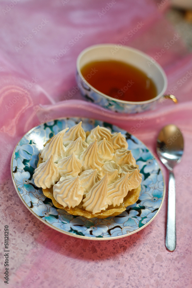 Portion meringue cake with tea on a table Portion meringue cake with tea on a table