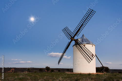 Typical windmill in with the moon at the background