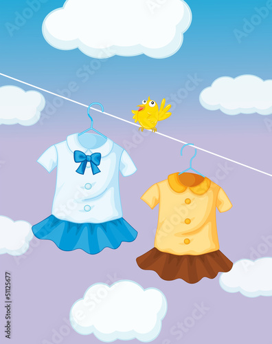 A yellow bird near the hanging uniforms