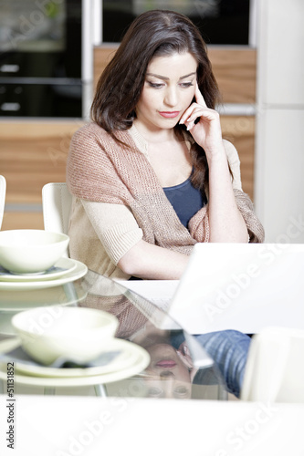 Woman using her laptop in kitchen