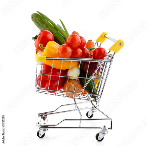 Shopping trolley full of vegetables on white background
