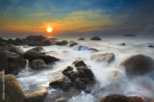 Sea waves lash line impact rock on the beach