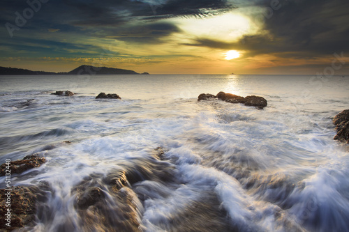 Sea waves lash line impact rock on the beach