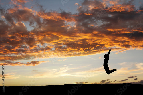 silhouette of teen jumping in sunset for fun