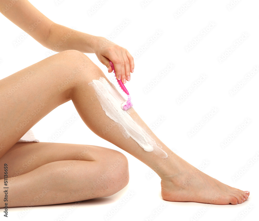 Beautiful woman is shaving her leg, isolated on white Beautiful woman is shaving her leg, isolated on white