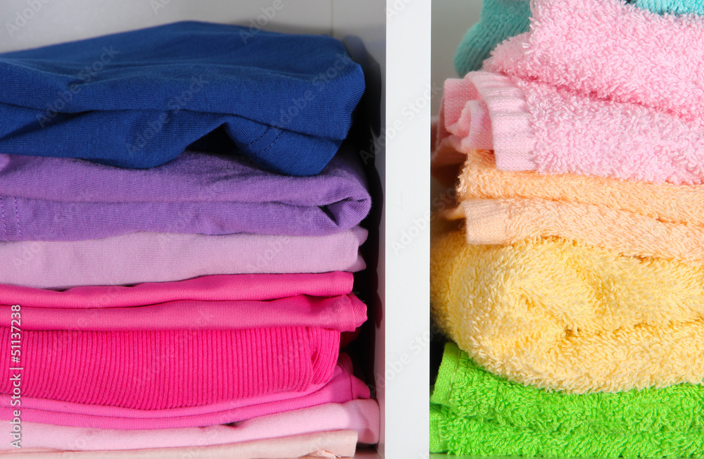 Clothes neatly folded on shelves Clothes neatly folded on shelves