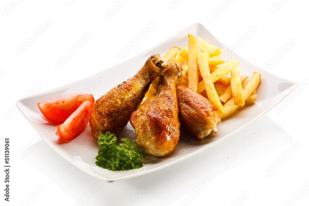 Grilled chicken drumsticks with chips and vegetables Grilled chicken drumsticks with chips and vegetables
