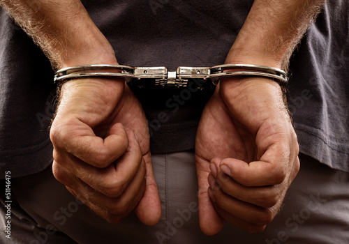 Foto Festgenommener Mann mit Handschellen gefesselte Hände auf der Rückseite