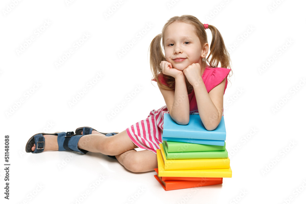 Smiling little girl sitting on floor leaning on stack of books Smiling little girl sitting on floor leaning on stack of books