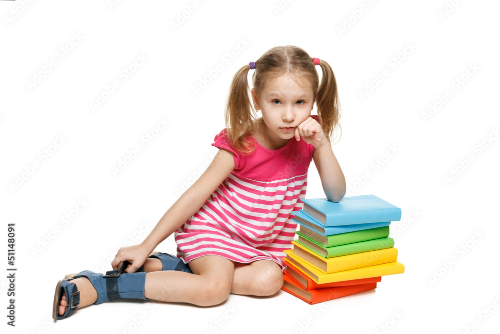 Little girl sitting on the floor leaning on the stack of books Little girl sitting on the floor leaning on the stack of books