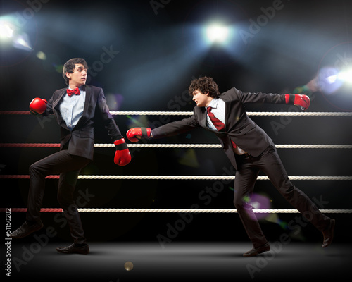 Two young businessman boxing