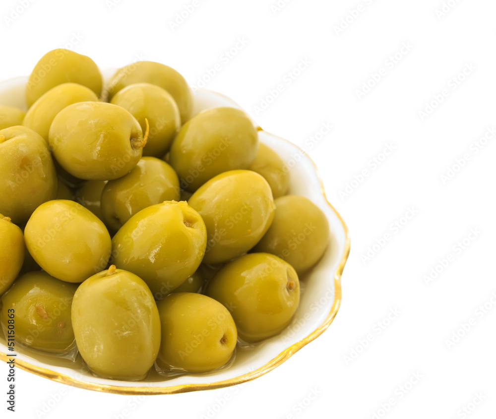 Green salt olives in a white dish with leaves isolated on white Green salt olives in a white dish with leaves isolated on white