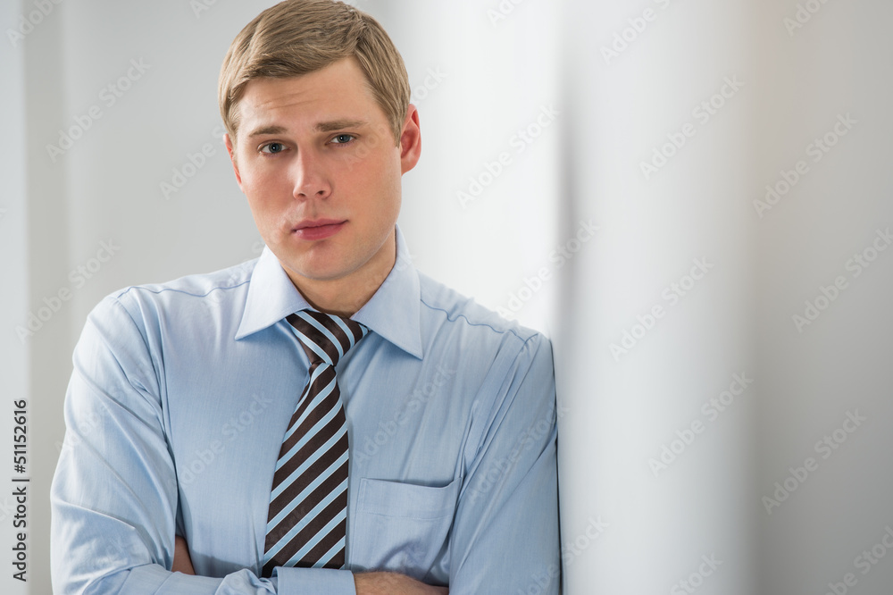 Portrait of a handsome young business man leaning against the wa Portrait of a handsome young business man leaning against the wa