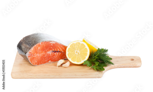 Salmon on cutting board with lemons and herbs