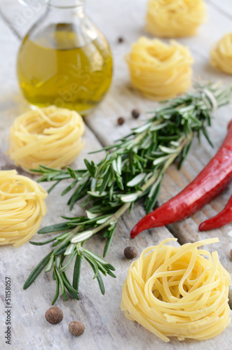 Raw tagliolini nest with rosemary, red chilli and allspice on wo