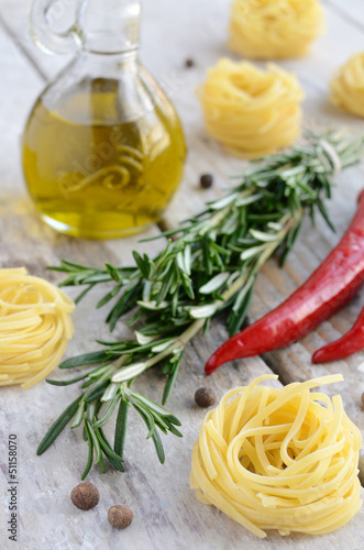 Raw tagliolini nest with rosemary, red chilli and allspice on wo