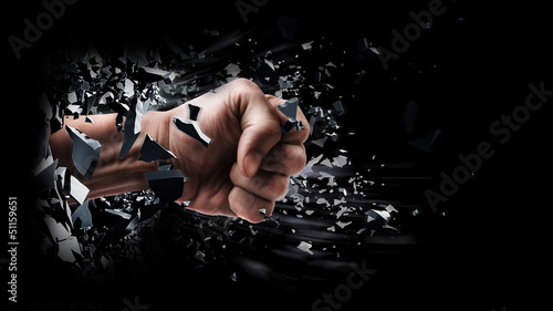 concept. power fist coming out of cracked ground isolated on black background