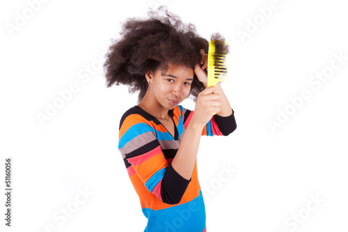 Black African American teenage girl combing her afro hair
