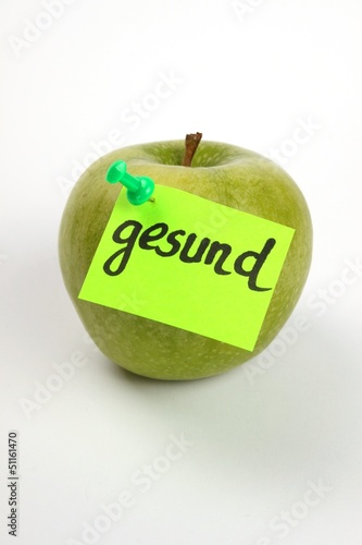 Ein grüner Apfel mit Pin und Notiz "gesund"