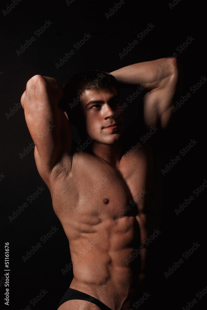 Young attractive man in a black bathing suit bodybuilder Young attractive man in a black bathing suit bodybuilder