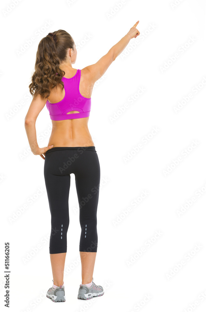 Full length portrait of fitness woman pointing on copy space Full length portrait of fitness woman pointing on copy space