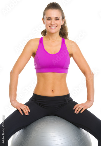Smiling fitness young woman sitting fitness ball