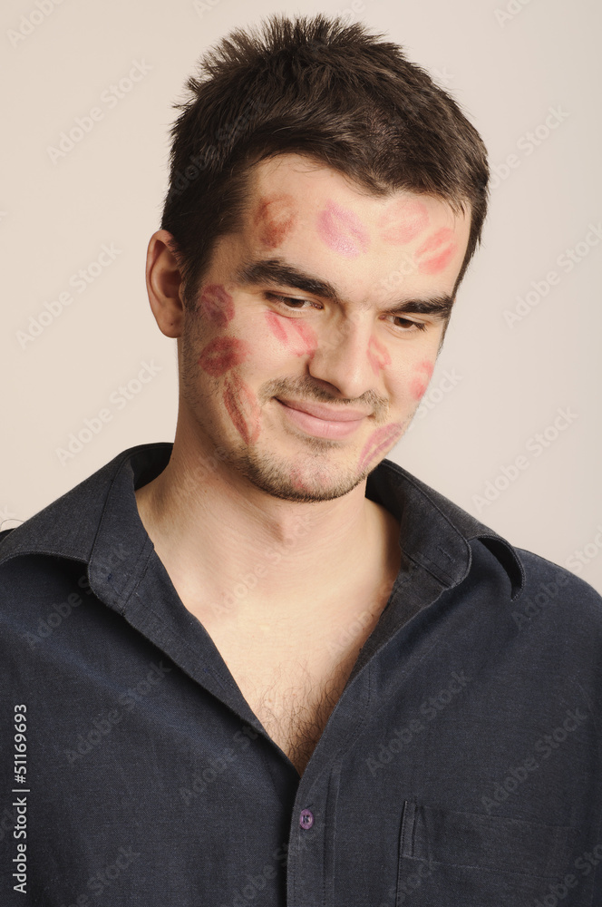 Fototapeta premium Cute guy with lipstick kisses on face