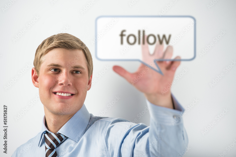 Handsome businessman pressing on follow button Handsome businessman pressing on follow button