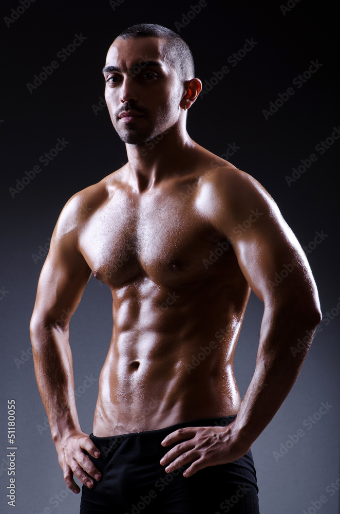 Obraz premium Muscular man in dark studio