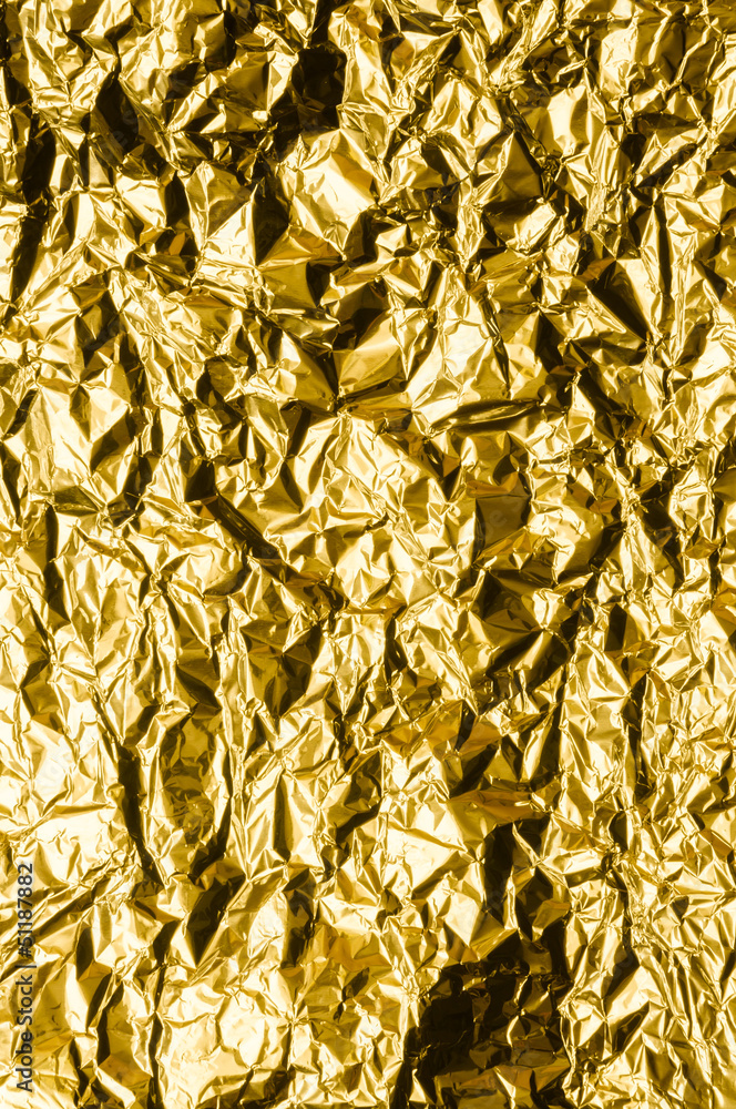 Crumpled gold metal foil with ambient reflection Crumpled gold metal foil with ambient reflection