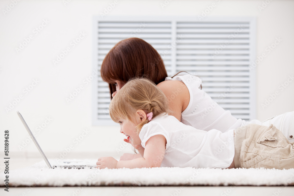 Mother with daughter looking on the laptop