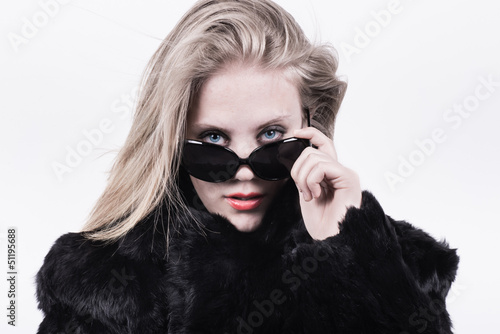 snobbish upper class girl in dark sunglasses and fur photo
