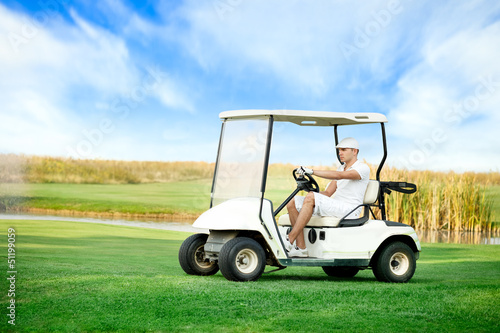 Young man driving golf buggy