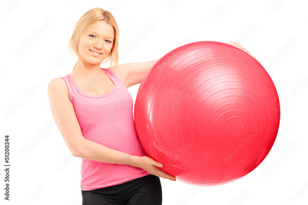 A blond female athlete holding a pilates ball A blond female athlete holding a pilates ball