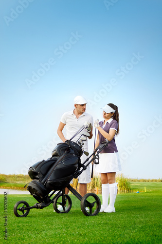Young sportive couple playing golf on golf course