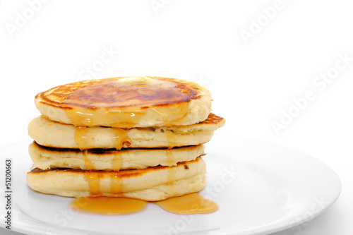 Stack of breakfast pancakes on plate with syrup