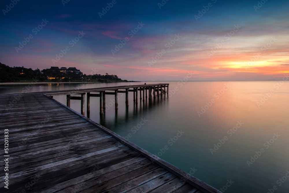 Fototapeta premium sunrise with dramatic sky and a jetty