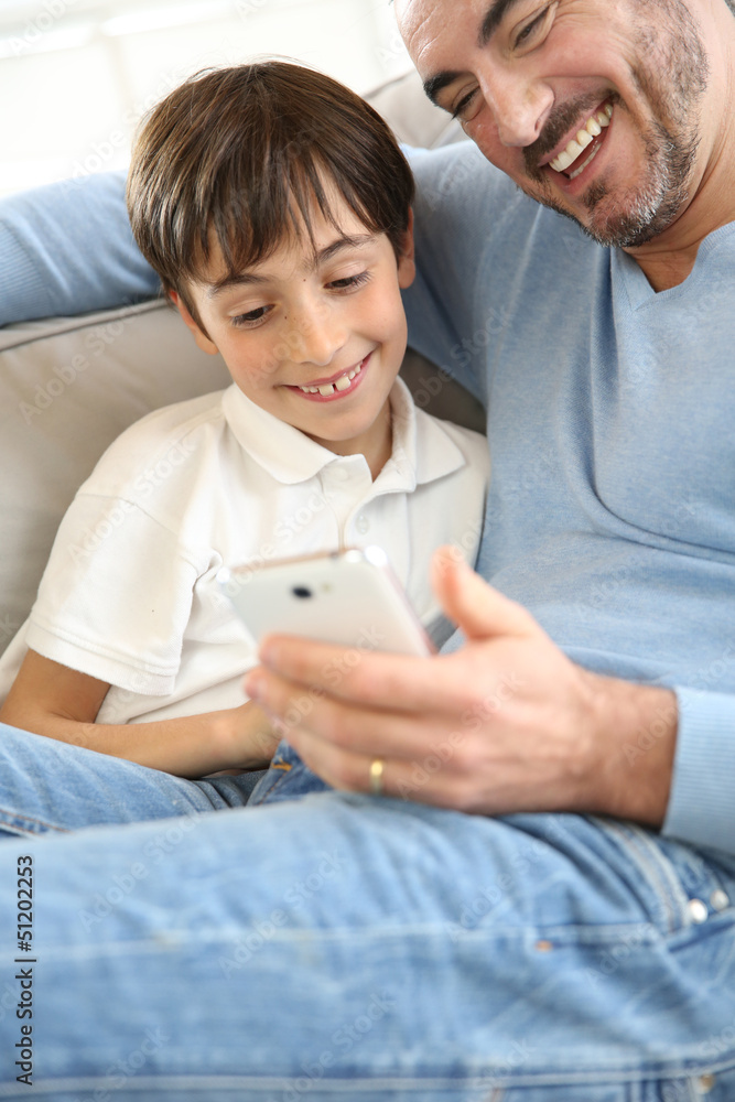 Little boy with dad playing with smartphone Little boy with dad playing with smartphone